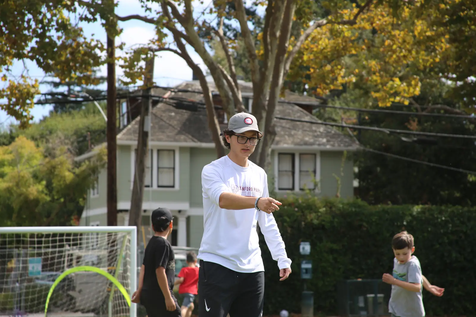 Coach guiding players through a drill on the school field