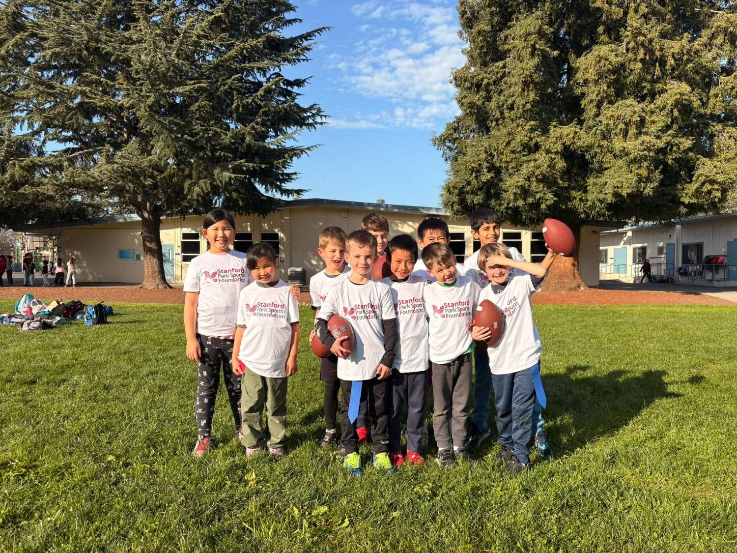 Flag football team in Foundation shirts holding footballs