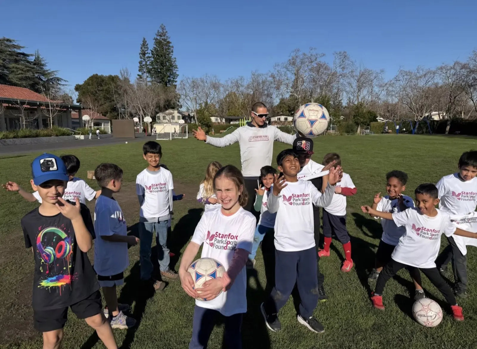 Students in Foundation shirts having fun at soccer with their coach