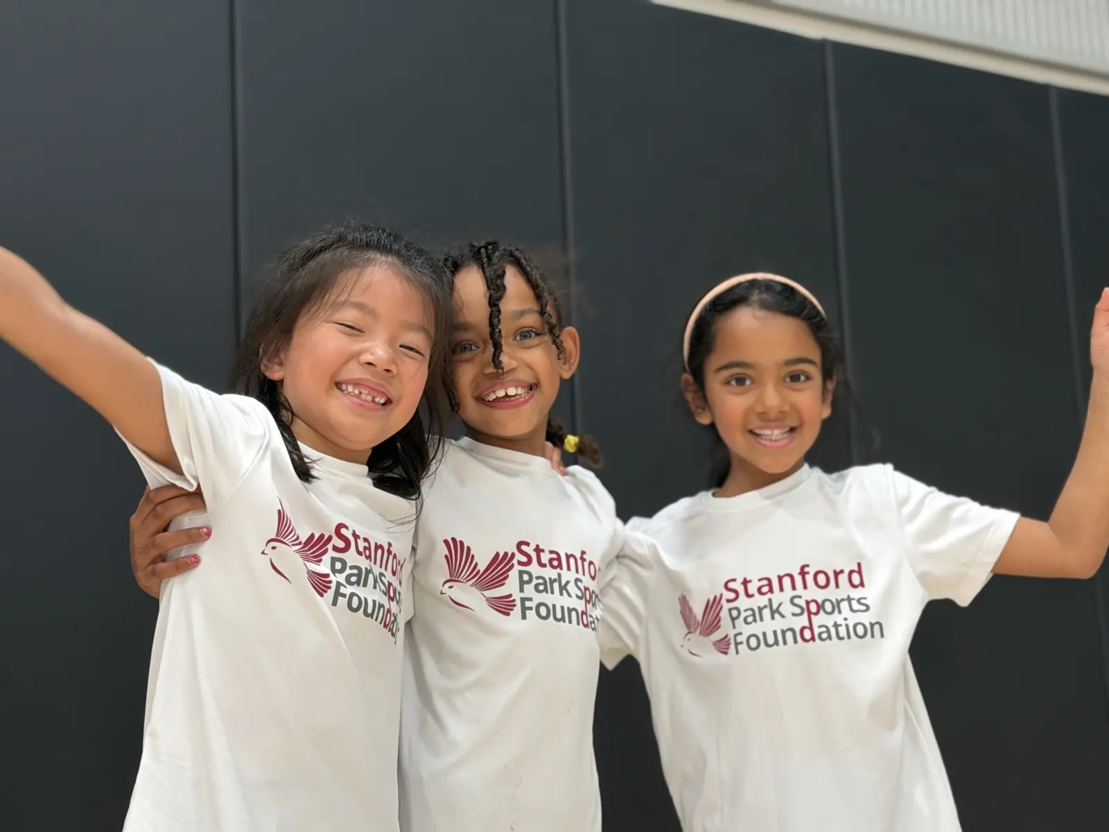Smiling girls in Stanford Park Sports Foundation shirts