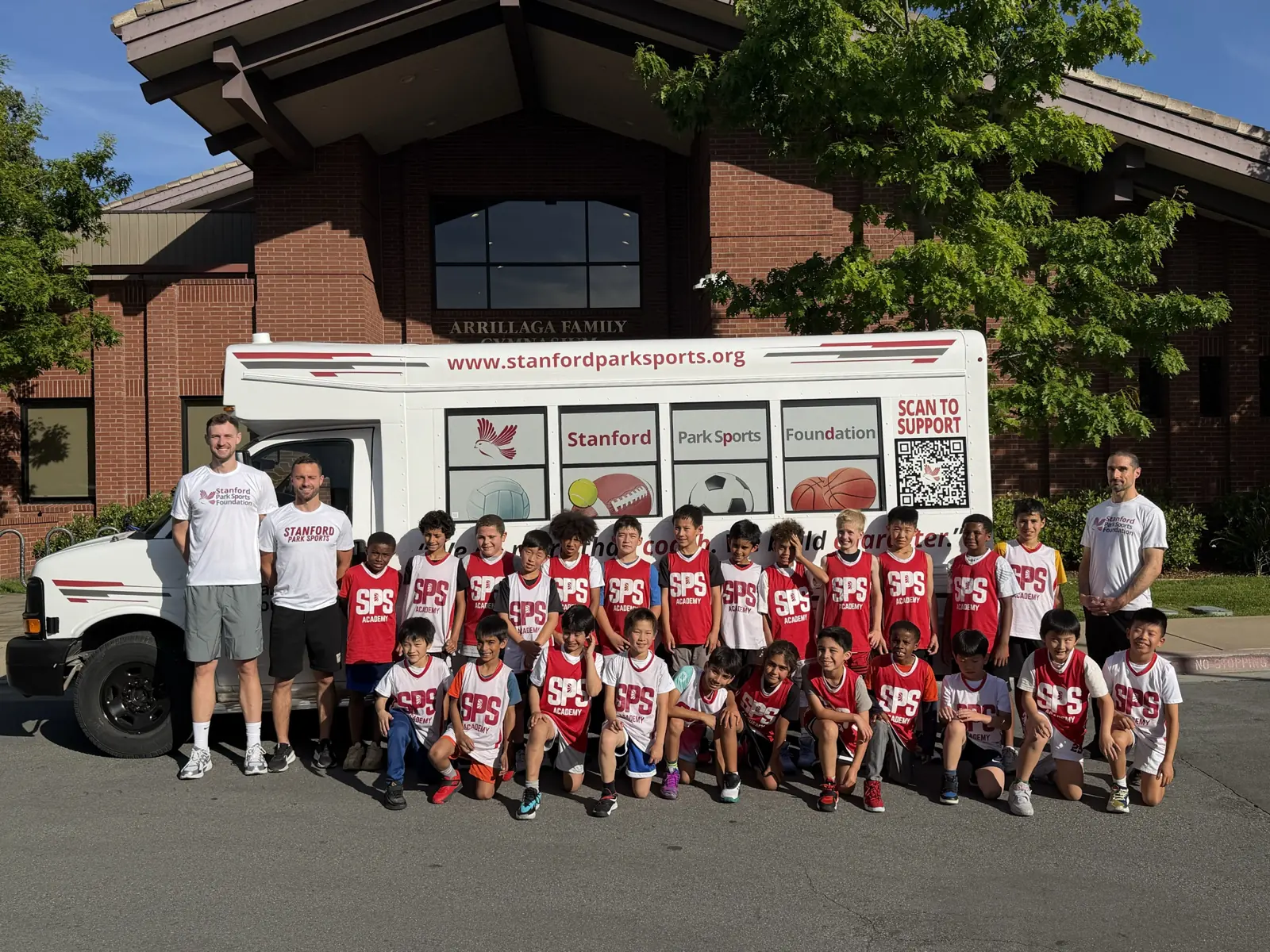 Students and coaches in front of the Stanford Park Sports Foundation bus